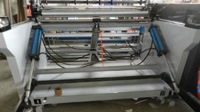 Estación de rebobinado con elevador hidráulico para la descarga de rollos terminados