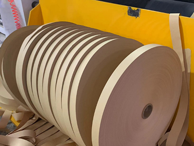 Unidad de rebobinado con cuchara de descarga que puede elevarse para proteger los rollos durante la operación