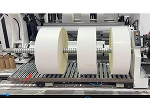 Sistema de descarga y transferencia de rollos terminados